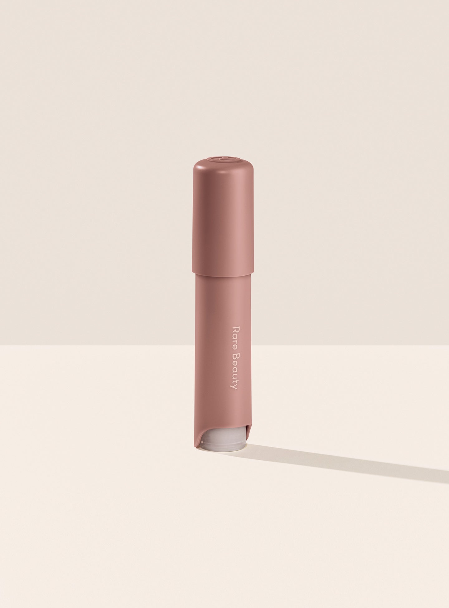 Rare Beauty's Find Comfort Stop & Soothe Aromatherapy Pen standing on a white table against a white background